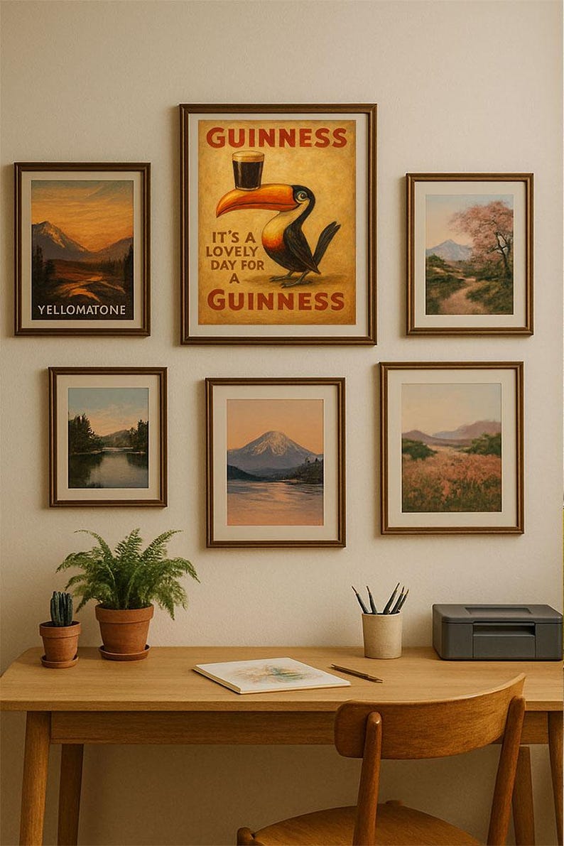 May include: A collection of framed art prints and a Guinness advertisement adorn a wall above a wooden desk. The prints depict landscapes, including mountains and a river. A Guinness poster features a toucan with a pint.