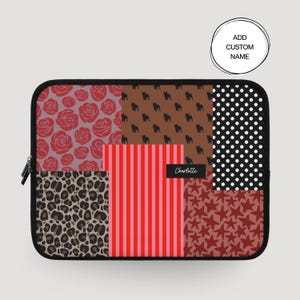 Puede incluir: Una funda para portátil de patchwork con cremallera negra. El diseño presenta varios patrones, incluyendo rosas rojas, siluetas de perros marrones, lunares negros, estampado de leopardo, rayas rojas y rosas y estrellas rojas. El texto "Charlotte" está en un rectángulo negro.