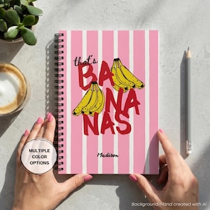 May include: A spiral-bound notebook with a pink and white vertical striped cover. The front features yellow banana illustrations and the red text that reads that's BANANAS. The name Madison is printed in black script near the bottom of the cover.