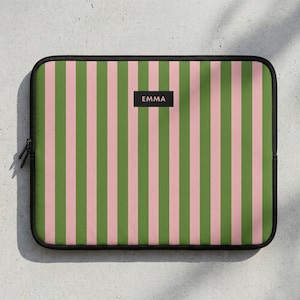 Könnte beinhalten: Rechteckige Laptop-Hülle mit vertikalem Streifenmuster in Rosa und Grün. Die Hülle hat einen schwarzen Reißverschluss und ein kleines schwarzes Rechteck mit dem Aufdruck "EMMA".