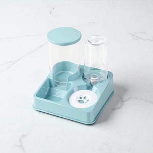 May include: A light blue pet feeder and waterer combo. The unit has a square base with a water bowl and a food dispenser. The water dispenser has a clear plastic bottle. The food dispenser has a light blue lid.
