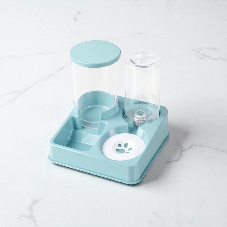May include: A light blue pet feeder and waterer combo. The unit has a square base with a water bowl and a food dispenser. The water dispenser has a clear plastic bottle. The food dispenser has a light blue lid.