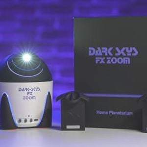 Pode incluir: Um projetor de planetário doméstico branco e preto com uma luz azul brilhando do topo. O projetor é etiquetado como "Dark Sky FX Zoom" e é cercado por quatro dispositivos pretos semelhantes a alto-falantes. A caixa do planetário é preta com o texto "Dark Sky FX Zoom" e "Home Planetarium" impresso nela.