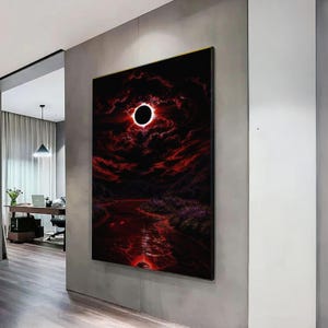 Può includere: Opera d'arte incorniciata raffigurante un paesaggio surreale con un cielo scuro e minaccioso e un cerchio nero luminoso. La scena presenta un fiume di tonalità rosse, con una cornice dorata. L'opera evoca un senso di mistero e drammaticità.