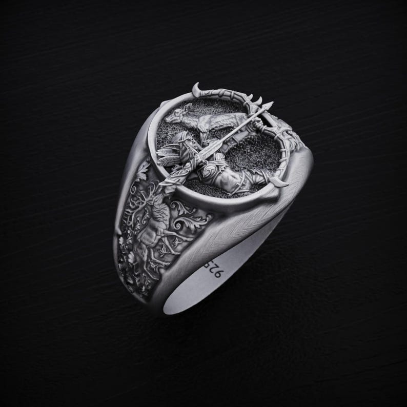 May include: A silver ring with a detailed design of a figure holding a bow and arrow. The ring is engraved with the number "576".