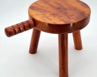 Taburete de ordeño vintage de madera de 3 patas con asa, estilo rústico.