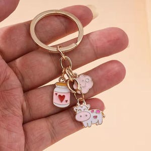 Lindo llavero de vaca de dibujos animados: dije de animal esmaltado con bebida y nube. Accesorio kawaii para llaves, bolsos y coche. Un regalo para ella o para él.