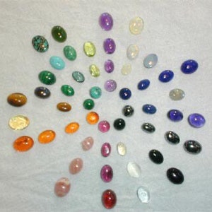 Puede incluir: Una colecci&oacute;n de piedras preciosas ovaladas dispuestas en un patr&oacute;n circular. Las piedras preciosas son de varios colores, incluidos el verde, el azul, el morado, el rojo, el naranja, el amarillo y el marr&oacute;n.