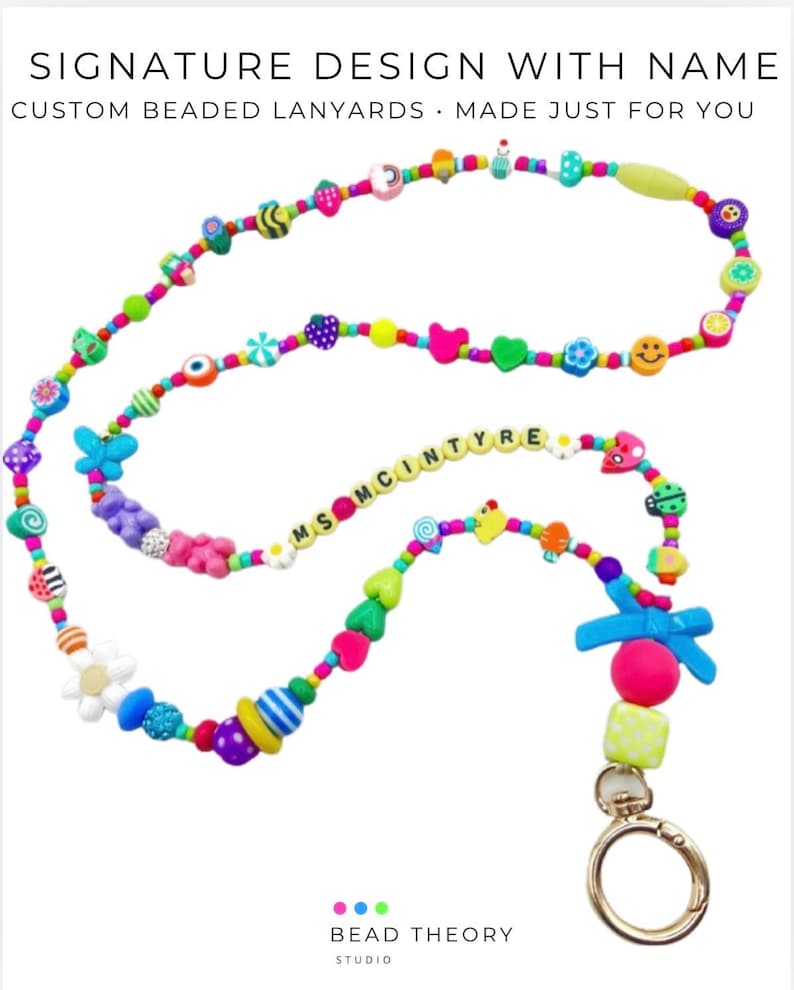 May include: A custom beaded lanyard featuring the text MS MCINTYRE, adorned with a variety of colorful shapes including flowers, butterflies, hearts, smiley faces, and gummy bears, finished with a gold-toned metal lobster clasp and a blue bow.