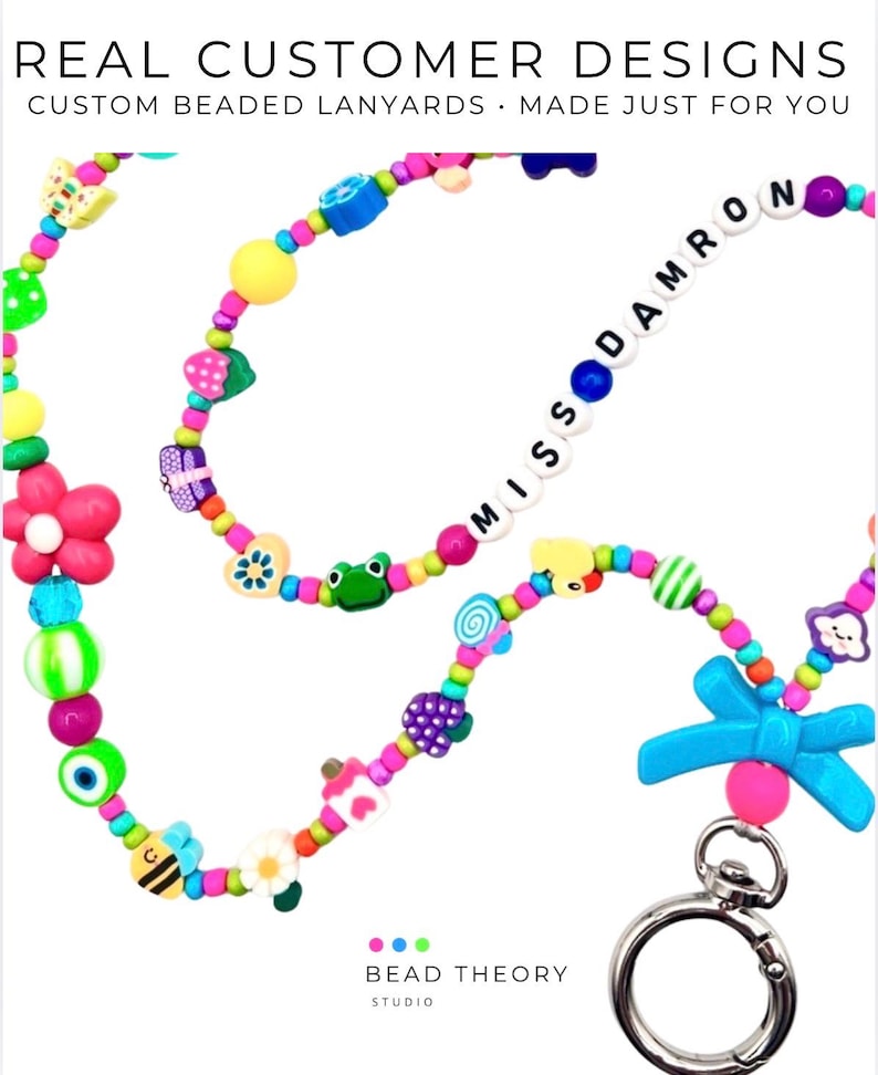 May include: A colorful beaded lanyard featuring a variety of shaped beads including flowers, frogs, butterflies, and a blue bow. The lanyard includes white letter beads spelling MISS DAMRON and a silver metal lobster clasp at the bottom end.