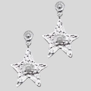 Pu&ograve; includere: Un paio di orecchini a forma di stella color argento. Ogni orecchino ha una superficie strutturata e una piccola perla rotonda al centro. Gli orecchini pendono da un piccolo perno rotondo.