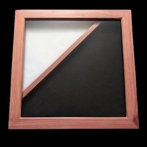 May include: A wooden picture frame with a diagonal divider, creating two sections. The top section is white, and the bottom section is black.