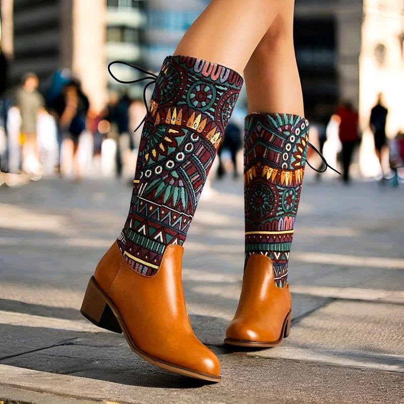 May include: Brown leather boots with a block heel and a colorful patterned fabric shaft. The fabric has a geometric design with shades of blue, green, red, and yellow.
