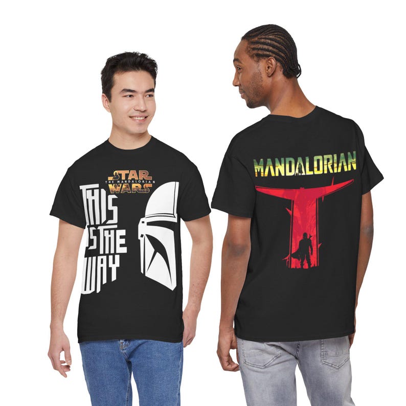 Può includere: T-shirt nere con grafiche di Star Wars e Mandalorian. Una maglietta presenta la scritta "THIS IS THE WAY" con un casco. L'altra mostra "MANDALORIAN" e una silhouette di personaggio.