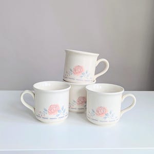 May include: A set of three ceramic mugs with a speckled, matte finish. The mugs are in shades of cream, light gray, and dark gray. Each mug has a simple, minimalist design, perfect for coffee or tea.