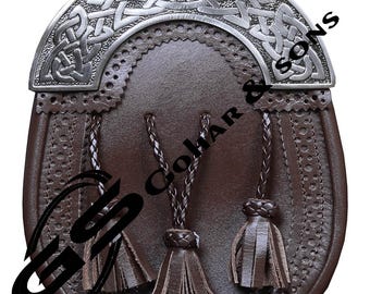 Könnte beinhalten: Braune Leder-Sporran mit silberfarbenem keltischen Knotenmuster auf der Klappe. Die Sporran hat drei Quasten und den Text "Gohar & Sons". Dieses traditionelle schottische Accessoire wird mit einem Kilt getragen.