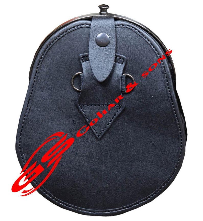 K&ouml;nnte beinhalten: Ein schwarzer Leder-Sporran, eine traditionelle schottische Tasche, mit abgerundeter Unterseite und Metallverschluss. Er hat einen Klappenverschluss mit Knopf und zwei Metallringen. Das Leder ist an den R&auml;ndern gen&auml;ht.