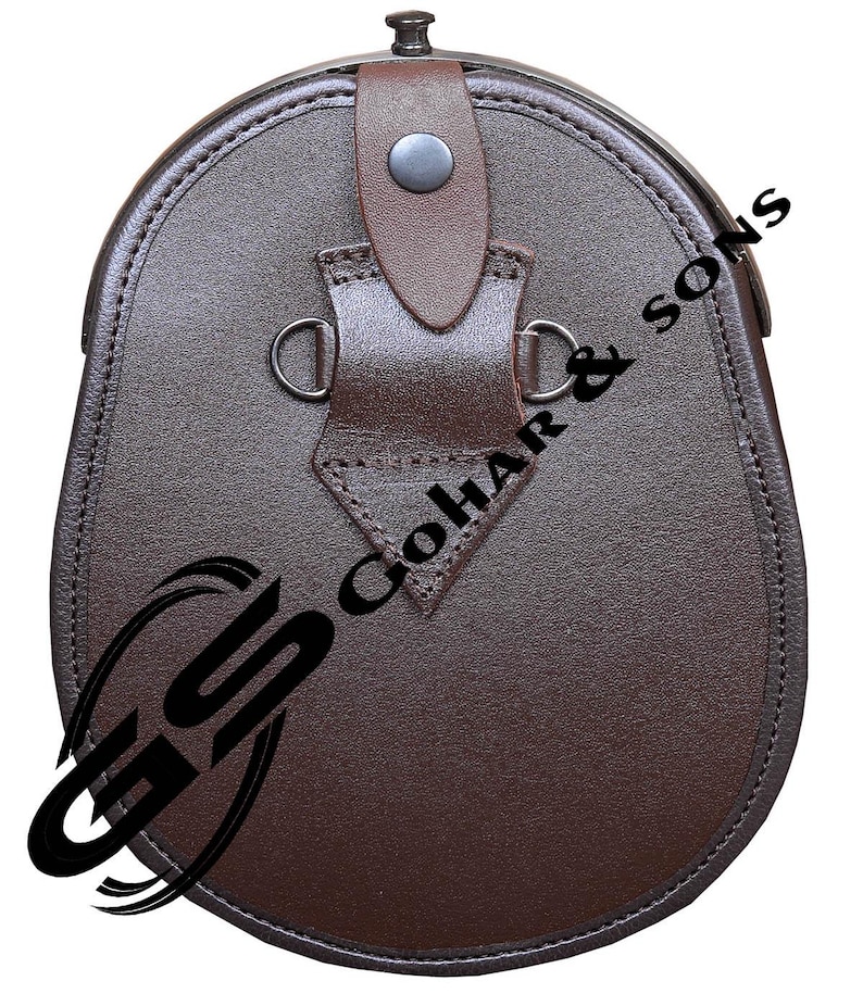 Pu&ograve; includere: Un sporran in pelle marrone con fondo arrotondato e chiusura a patta. Presenta un cinturino decorativo con un bottone e due anelli metallici. Il testo "GoHar & Sons" &egrave; visibile in basso a sinistra.