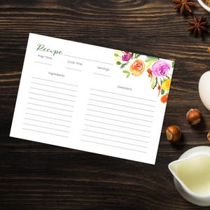 May include: White recipe card with floral watercolor design in pink, orange, and yellow. The card has lines for ingredients and directions, with headings for prep time, cook time, and servings. The word "Recipe" is written in green script.