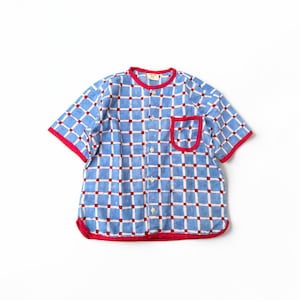 May include: A short-sleeved button-down shirt featuring a blue and white grid pattern with small red squares at each intersection. The shirt has a round neckline, a single chest pocket, and bright red trim along the collar, pocket, and hem.