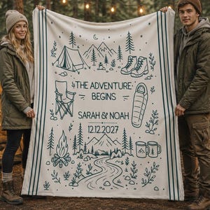 May include: A cream-colored throw blanket featuring dark teal line art of camping gear, including a tent, boots, a chair, a sleeping bag, a campfire, and trees. The text reads THE ADVENTURE BEGINS, SARAH & NOAH, and the date 12.12.2027.