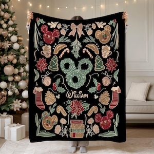 Puede incluir: Manta negra con tem&aacute;tica navide&ntilde;a y dise&ntilde;o festivo. Presenta hombres de jengibre, adornos con forma de Mickey Mouse, bastones de caramelo y flores de Nochebuena. El nombre "William" est&aacute; escrito en cursiva.