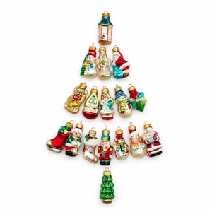 May include: A collection of nineteen small glass Christmas ornaments arranged in a tree shape. The set includes figures of Santa Claus, snowmen, a nutcracker, a teddy bear, a stocking, a lantern, and a green tree, all featuring vibrant colors.