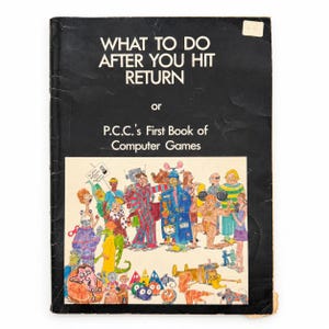 May include: A black book titled WHAT TO DO AFTER YOU HIT RETURN or P.C.C.'s First Book of Computer Games. The cover features a colorful, detailed illustration of various cartoon characters, including people, creatures, and robots in a busy scene.
