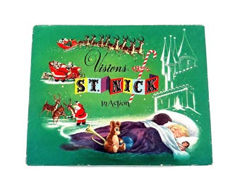 May include: A rectangular green box featuring the text Visions of ST. NICK In Action. The illustration depicts Santa in a sleigh with reindeer, a candy cane, a castle, and a child sleeping in a bed with a teddy bear and a toy trumpet.