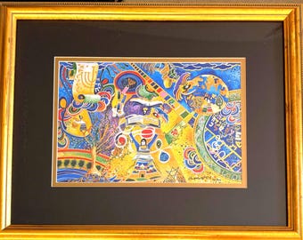 May include: Colorful, framed artwork with a gold frame. The artwork features a vibrant, abstract design with various shapes, symbols, and figures in shades of blue, yellow, red, and green. The artwork is matted with a black mat.