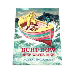 May include: A vintage book cover with a watercolour illustration of a man in a yellow raincoat fishing from a colourful boat. The title "BURT DOW DEEP-WATER MAN" is displayed, with the author's name below.