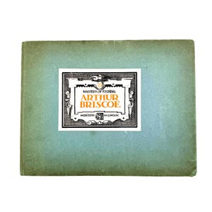 May include: A vintage book titled "Masters of Etching Arthur Briscoe" with a light teal cover. The book's title is displayed on a white and black label. The label also includes the address "44 Leicester Sq London."