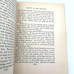 May include: Open book pages with text, featuring the title "BLOODY AS THE HUNTER." The text is in black font on aged, off-white paper. Page numbers are visible at the bottom. The book appears to be a vintage novel.