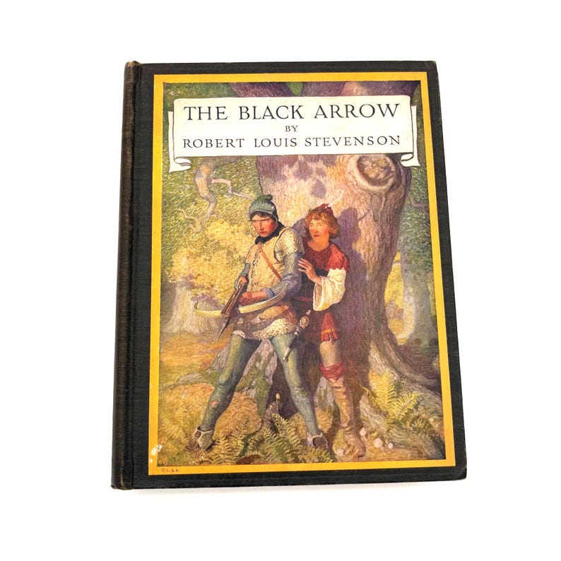 May include: A hardcover book titled "THE BLACK ARROW" by Robert Louis Stevenson. The cover features an illustration of two young men in medieval attire, one holding a crossbow, set against a forest backdrop. The book has a black spine and a yellow border.