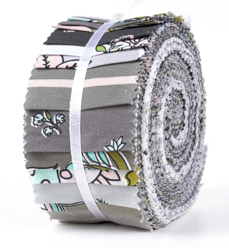 May include: A roll of fabric featuring a variety of prints in shades of gray, pink, green, and blue. The fabric is rolled up and tied with a white ribbon.