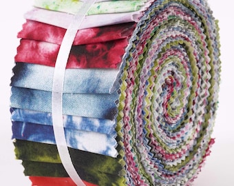 Puede incluir: Un rollo de tiras de tela coloridas, sujetas con una cinta blanca. La tela presenta diseños de teñido anudado y acuarela en tonos rojos, azules, verdes y morados. Los bordes de la tela son en zigzag.
