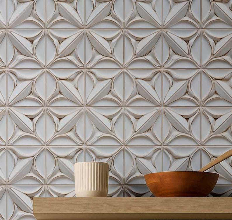 May include: White ceramic wall tiles with a repeating floral pattern. A small, beige, ribbed ceramic cup and a wooden bowl are on a wooden shelf. A wooden spoon rests in the bowl.