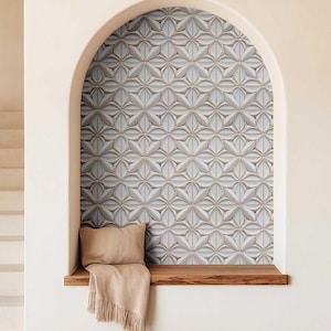 May include: A decorative wall panel with a repeating floral pattern in shades of white, gray, and beige. The panel is set within an arched alcove, with a wooden bench, a beige pillow, and a fringed throw. The overall aesthetic is modern and elegant.