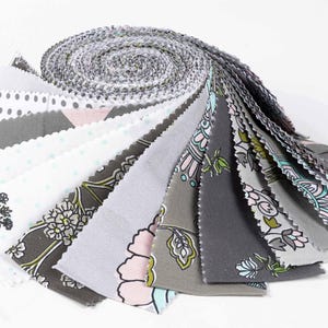 May include: A roll of fabric scraps in various shades of gray and white with floral and polka dot patterns. The fabric is pre-cut into 2.5 inch squares.