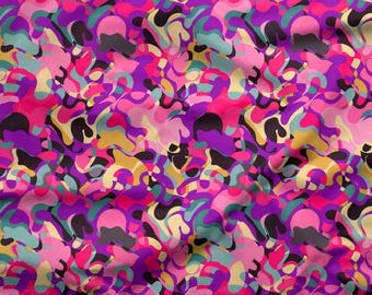 May include: A colourful fabric featuring an abstract pattern of swirling shapes in pink, purple, yellow, teal, and black. The design has a retro feel, with a ruler in inches at the bottom, and the measurements are in centimetres.
