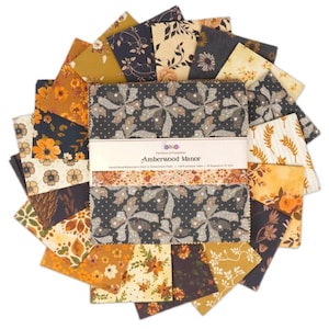 May include: A selection of fabric squares with floral and botanical designs in gold, navy, and brown hues. The central stack has a label reading "Amberwood Manor". The fabric squares are likely for quilting or crafting.