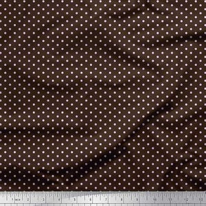 Op de afbeelding: Bruine stof met een wit stippenpatroon. De stof heeft een gekreukte textuur en een liniaal staat onderaan de afbeelding, met afmetingen in inches en centimeters.