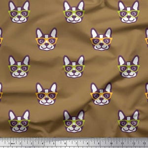 May include: Brown fabric featuring a repeating pattern of purple and white French bulldog faces wearing eyeglasses in various colors. The eyeglasses are yellow and green. The pattern is measured in centimetres.