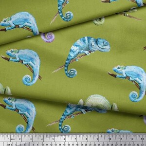 May include: A patterned fabric featuring blue chameleons on brown branches, set against a light green backdrop. The chameleons are rendered in a watercolor style, with blue and green hues. The fabric is measured in centimeters.