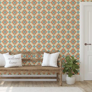 May include: A room interior featuring a wooden bench with white pillows, a potted plant, and a patterned wallpaper. The wallpaper has a repeating floral design in orange, teal, and cream. One pillow has the text "welcome home".