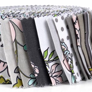 May include: A roll of fabric scraps in various shades of gray, white, and pink with floral and polka dot patterns.
