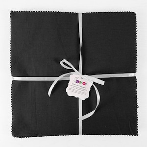 May include: A package of 40 pre-cut black fabric squares, 5 inches by 5 inches, tied with a white ribbon and a tag that reads "40 Pre-cut Squares 100% Cotton Fabric Squares 5" of 12.7 cm Squares"