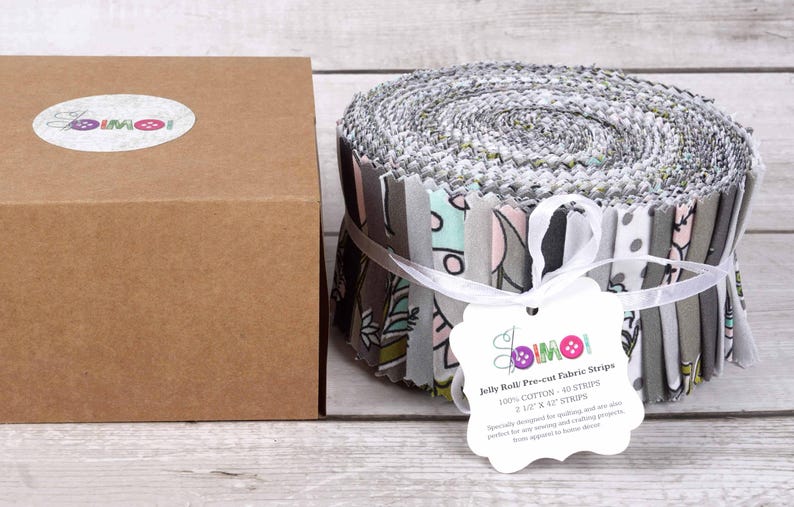 May include: A roll of gray and white fabric strips with a floral pattern. The fabric is labeled "Jelly Roll Pro-cut Fabric Strips" and is 100% cotton. The roll is 2.5 inches wide and contains 40 strips.