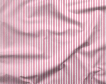 May include: Pink and white striped fabric with vertical lines. The fabric has a wrinkled texture, with the stripes running the length of the material. The image includes a ruler with inches and centimeters.