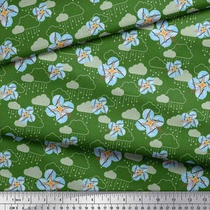 May include: Green fabric with a repeating pattern of light blue flowers with orange centers, gray clouds, and white rain lines. The pattern is measured in inches.